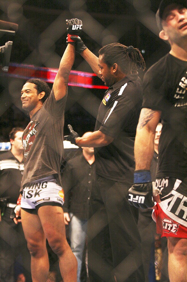 Decatur graduate Benson Henderson gets his hand raised by referee Herb Dean after beating Frankie Edgar (right) at UFC 150 inside Denver's Pepsi Center Saturday night. The win kept Henderson as the UFC's lightweight champion.