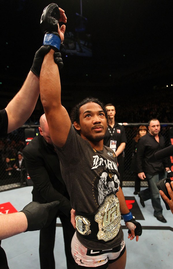 Decatur graduate Benson Henderson gets the UFC lightweight championship belt strapped around his waist by UFC President Dana White after beating Frankie Edgar at UFC 144 Saturday in Tokyo.