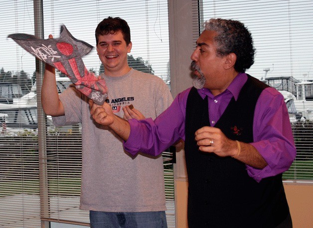 Kirkland performer Ruben Barron performs some of his magic tricks with assistance from audience member Matt Kinney during his recent magic and comedy show at Fieldwork Seattle Inc. located at Carillon Point in Kirkland.